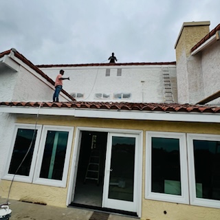 men on roof above back entranceway